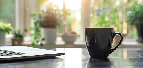 Cup of coffee with laptop on a sunny kitchen table