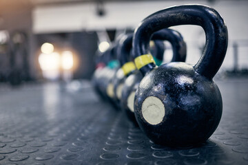 Exercise, kettlebell and weights on floor of gym for training, wellness or workout with space. Background, metal equipment in health club and fitness for action, physical improvement or strength