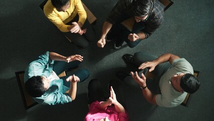 Top down aerial view of business people clap hands together to celebrate successful project while...