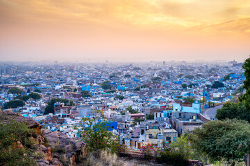 aerial drone shot at dusk sunset showing jodhpur blue city cityscape showing traditional houses in middle of aravalli with colorful densely packed houses