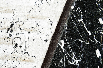 A wall with black and white paint splatters, creating a contrasting