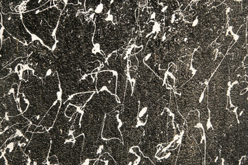 A black and white photo of a wall with white splatters