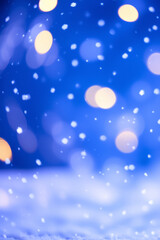Abstract background with white snowflakes and lights on a blue background.