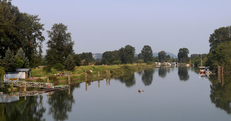 Fototapeta na wymiar Tranquil river reflecting moored boats