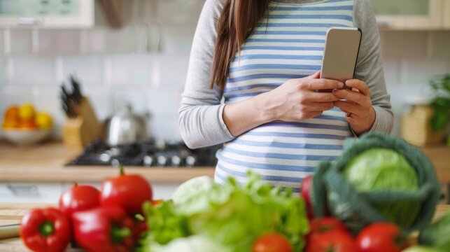 Pregnant Woman Using Cell Phone in Kitchen