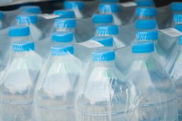 A row of plastic bottles of water are wrapped in plastic