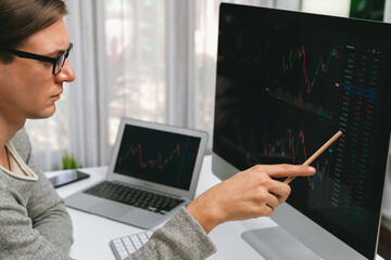 Smart stock investors pointing interesting market stock exchange on pc with laptop screen. Financial technology dynamic investment plan focusing data graph on monitor at modern workplace. Pecuniary.