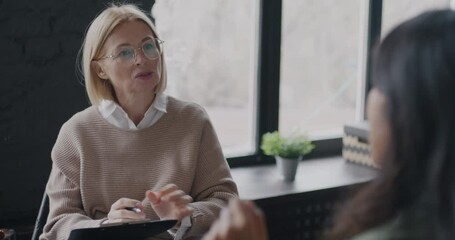 Professional therapist talking to female client discussing problem working with patient in office. Therapy and psychologist concept.