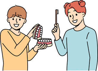 Happy children show rules of brushing teeth and using dental toothbrush to get rid of bacteria in mouth. Little boy and girl advise peers to take care of dental health of teeth and gums.
