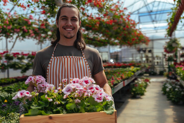 Male gardener presenting pink flowers