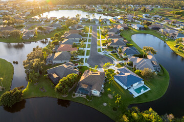 Cul de sac street dead end at sunset and private residential houses in rural suburban sprawl area in North Port, Florida. Upscale suburban homes with large waterfront backyards