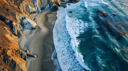 A detailed view of a beach meeting cliffs from above, showcasing the natural landscape and coastal...