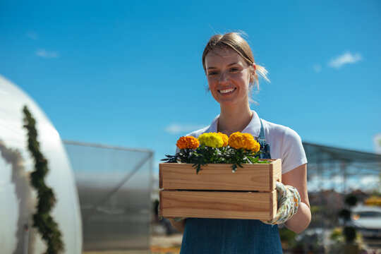 Smiling woman holding a box of flowers