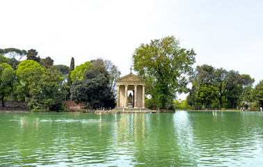 Lake in the gardens of villa Borghese with the temple of Asclepius in the background