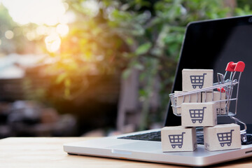 Shopping online. cardboard box with a shopping cart logo in a trolley on laptop keyboard. Shopping service on The online web. offers home delivery