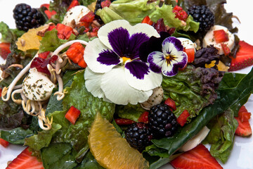 Fruit salad with vegetables and berries on a restaurant table accompanied with dressings, healthy food