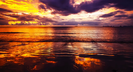Burning sky and sea in vibrant spectacular yellow golden colors during sunset over the ocean...