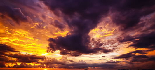 Storm clouds dissolve after thunderstorms with spectacular sunset in strong yellow-golden colors...