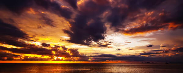 Calm after the storm - Dark rain clouds after thunderstorm in spectacular sunset over smooth...