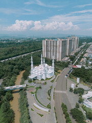 Aerial photo of a grand mosque in the heart of the city, flanked by two apartment buildings, symbolizing the harmony of urban life and spirituality