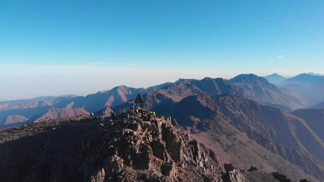 Toubkal, Morocco - Drone view in 4K of a group of climbers resting at the summit of Toubkal in the Atlas Mountains - CIRCA 2021
