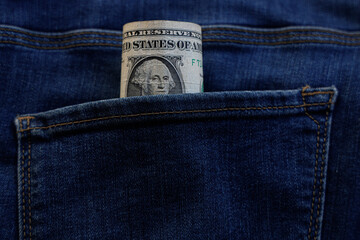 Banknote of north american one dollar bill in blue jeans pocket background. bill of 1 american bucks sticking out of the back denim pocket. US Currency. first american president George Washington