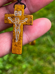 A rosary cross held in a hand, close-up