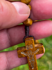 A rosary cross held in a hand, close-up