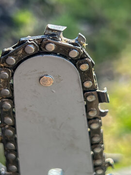 Close-up of a chain on the guide bar of a small wood chainsaw