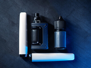 Electronic cigarette pod system with replaceable refillable cartridges, salt liquid and disposable e-cigarette. Top view , black background