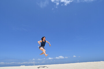 ビーチでジャンプする女の子（フィリピン、パンダノン島）