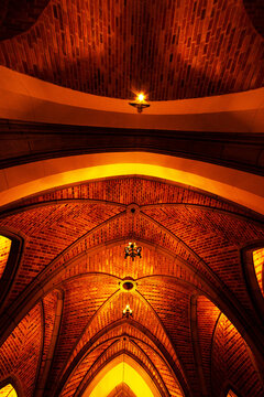 Teto de cripta, lustre, textura e luz amarela. 