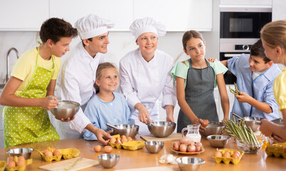 Chef apprentices learn how to properly beat eggs with a whisk in a cooking class