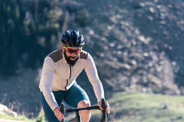 A man wearing a helmet and sunglasses is riding a bicycle on a mountain