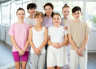 Group portrait of cheerful teenage dancers in row in a choreographic studio