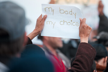 Poster, rally and protest crowd with abortion, freedom and equal rights for change, power or transformation. Body, choice or group of people with banner for reproductive, law and government attention