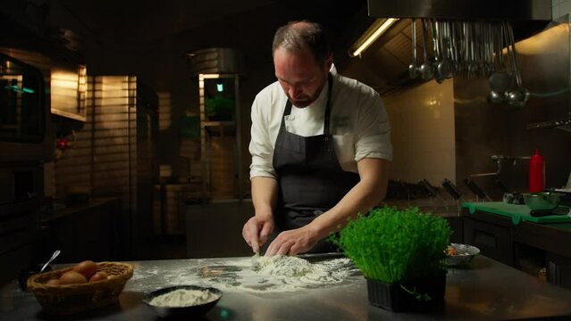 Chef Making The Dough With Flour Eggs And Cuttlefish Ink Food Into Restaurant