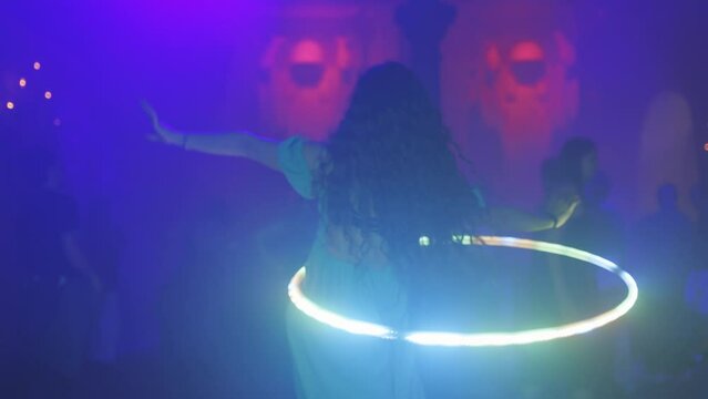 A woman is dancing in a circle with a hula hoop