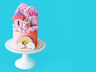 Cute pink birthday cake for a little girl with fondant unicorn, with gingerbread cookies isolated on blue background, horizontal orientation