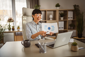 Mature japanese woman hold document and have consultation via video call