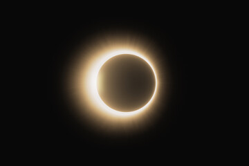 Solar corona glowing during a total solar eclipse on a black background.