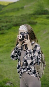 Woman tourist shoots amazing landscape with instant camera