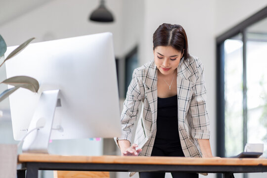 
Portrait of an Asian businesswoman smiling while sitting at her desk.doing planning analyzing the financial report, business plan investment, finance analysis concept.