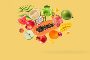 Assortment of different fruits falling on yellow background. - 794545478