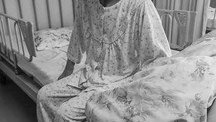 ベッドに座る高齢の日本人女性