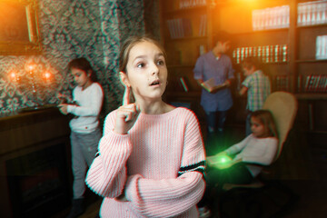 Pensive tween girl trying to solve riddles in quest room. Toned image with visual effect
