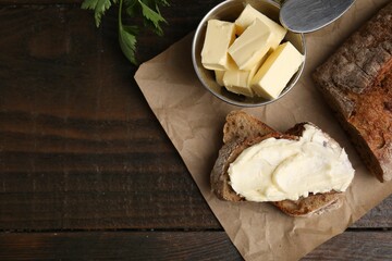 Tasty bread with butter on wooden table, flat lay. Space for text