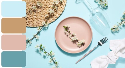 Beautiful table setting with blossoming branches on blue background. Different color patterns