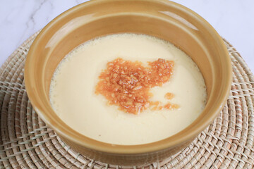 Steamed egg with garlic on white table. Thai street food restaurant menu. Home cooking concept.