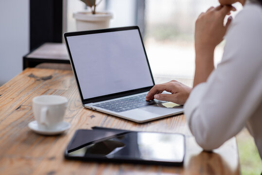 Closeup of hands typing on a laptop keyboard, Freelancer working on laptop at desk in loft office